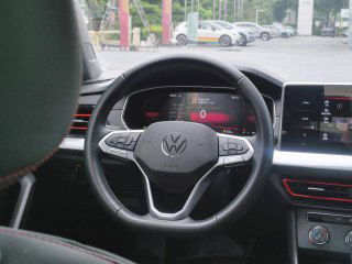 Рулевое колесо Volkswagen Lavida с подсвеченными элементами приборной панели и цифровым дисплеем спидометра, декоративные красные вставки видны.