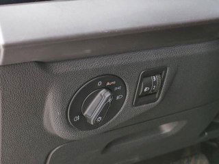 Крупный план блока управления освещением на панели Volkswagen Lavida: переключатель фар, регулировка и текстура панели рядом с рулевой колонкой.