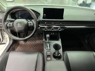 Интерьер Honda Civic 2022 — вид на рулевую колонку и центральную консоль с мультимедиа-экраном и селектором вариатора.