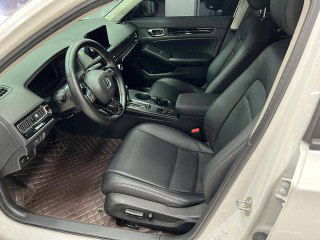 Вид с водительского места и переднего пассажира в Honda Civic 2022: кожаный салон, панель приборов и дверная карта крупным планом.