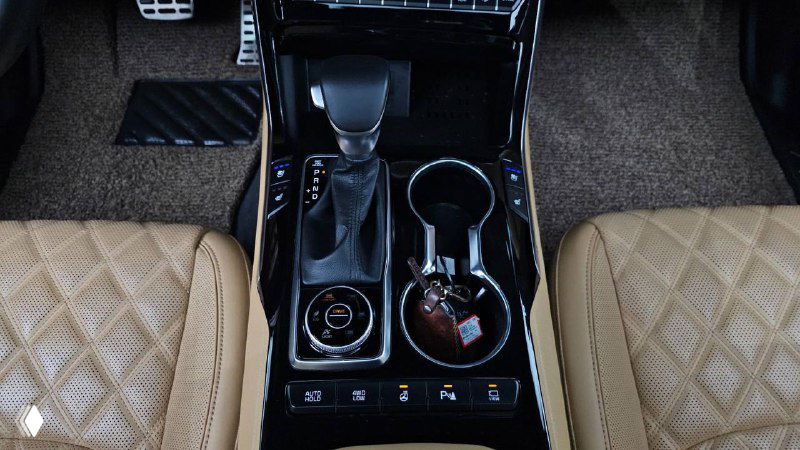 Центральная консоль KIA Mohave: селектор АКПП, подстаканники и элементы управления, фото показывает качество отделки и материалы салона.