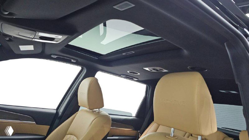 Панорамный люк в крыше салона KIA Mohave и передние сиденья в бежевой коже: иллюстрация опций комфорта и освещения в салоне.