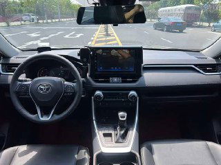 Интерьер второго Toyota RAV4 2021: вид на рулевую колонку и центральную панель с большим экраном мультимедиа и портами.