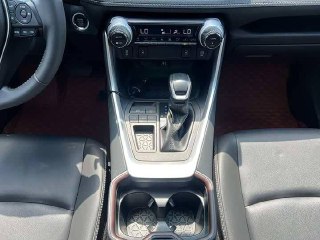 Крупный план центральной консоли второго Toyota RAV4 2021: селектор коробки, подстаканники и элементы управления климатом.