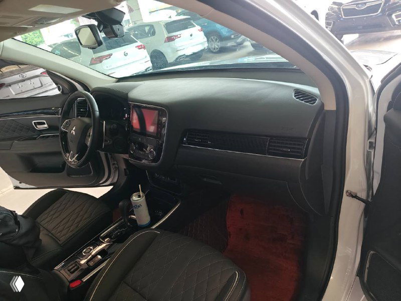 Передняя пассажирская зона Mitsubishi Outlander 2021: торпедо, центральная консоль с экраном и дверная карта в салоне демонстрационного образца.