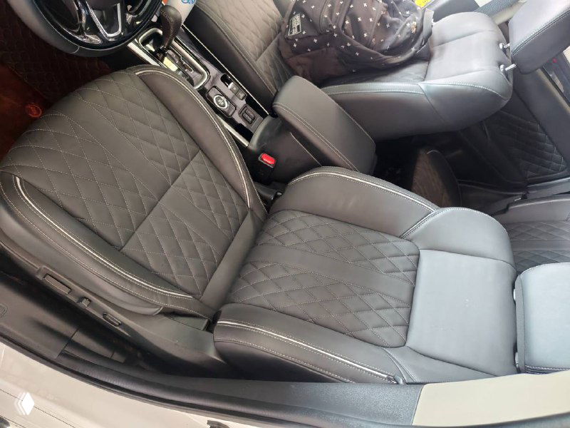 Кресла водителя и переднего пассажира Mitsubishi Outlander 2021 в комбинированной отделке; крупный план на сиденья, строчка и подлокотник.