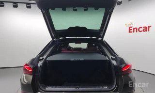 Багажный отсек BMW X6 xDrive 40i M‑Sport 2021 с открытой дверью: объём багажника, складывающийся вариант груза и чистая отделка, вид сзади автомобиля в студии.