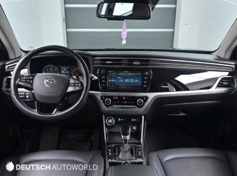 Интерьер Ssangyong Korando: руль, мультимедийный экран и торпедо, показаны элементы управления и состояние салона со стороны водителя.