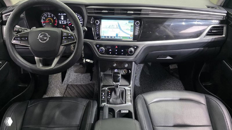 Салон Ssangyong Korando 2020: панель приборов, мультимедиа-экран и центральный туннель с селектором АКПП, кожаная отделка сидений видно в кадре.