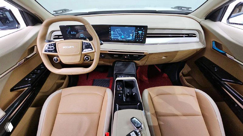 Салон SsangYong Actyon — панель приборов и мультимедийный дисплей, бежевая отделка сидений и торпедо, вид центральной консоли спереди.