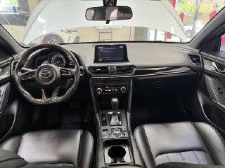 Салон Mazda CX‑4: панель управления, мультимедиа экран и передняя консоль — чёрная отделка, общий вид приборной панели и центральной части.