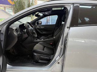 Открытая передняя дверь Mazda CX‑4 и вид на водительское пространство — показаны посадочная позиция, порог и оформление дверного проёма.