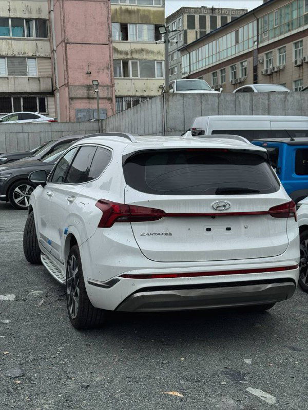 Задняя часть белого Hyundai Santa Fe 2022 на парковке; крупный план багажной двери и задних фар, автомобиль выставлен после доставки для клиента.