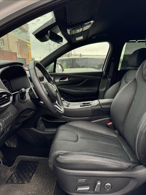 Общий вид передних сидений и водительского пространства Hyundai Santa Fe 2022 — чёрная кожа, электрорегулировки сидений и современная отделка салона для комфорта пассажиров.