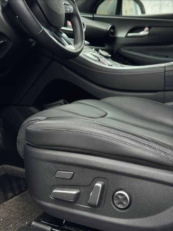 Крупный план электрорегулировок и боковой части переднего пассажирского сиденья Hyundai Santa Fe 2022 — вид на регулировки положения и качество кожаной обивки.