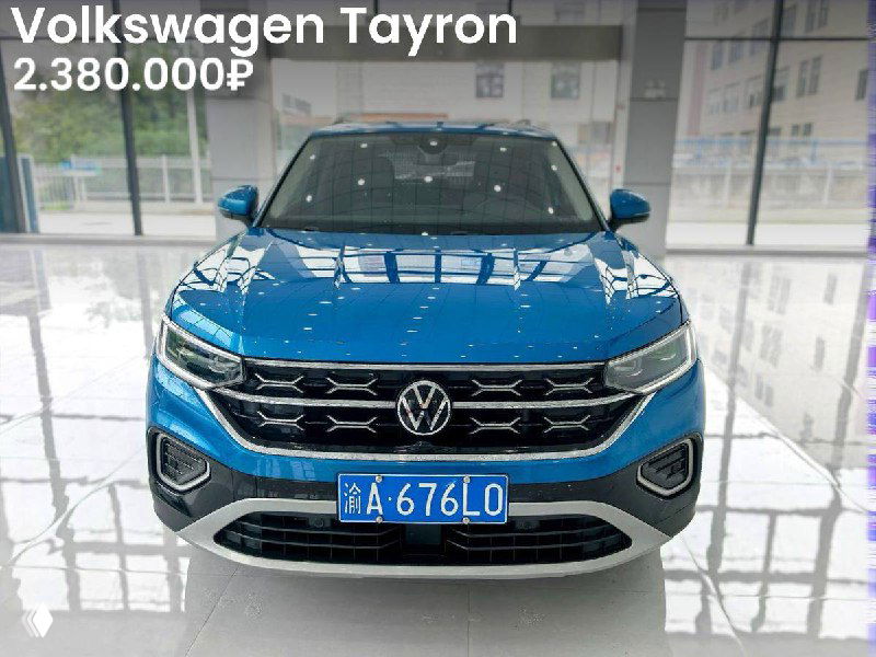 Синий Volkswagen Tayron в шоу-руме, вид спереди; демонстрация состояния автомобиля и цена 2.380.000₽ на объявлении импорта из Китая.