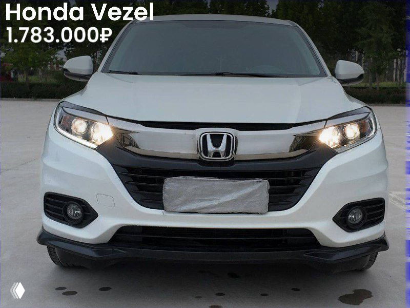 Передняя часть белого Honda Vezel, вид спереди, городской паркинг, указана цена 1.783.000₽ на фото варианта из Китая.
