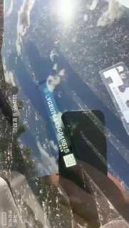 Крупный план наклейки и документов на лобовом стекле автомобиля с датой и идентификационными метками, подтверждающими состояние и подготовку к отправке.