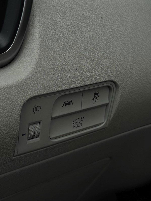 Блок управления ассистентов и элементы на панели водителя KIA Sorento — крупный план кнопок систем безопасности и помощи.