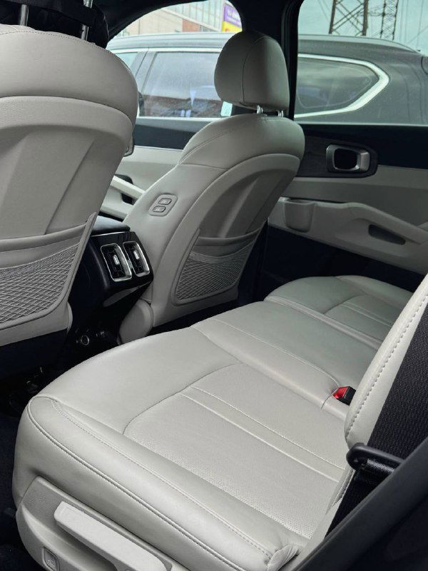 Задний ряд сидений KIA Sorento — светлая кожаная обшивка, подлокотник и воздуховоды заднего климат-контроля в кадре.