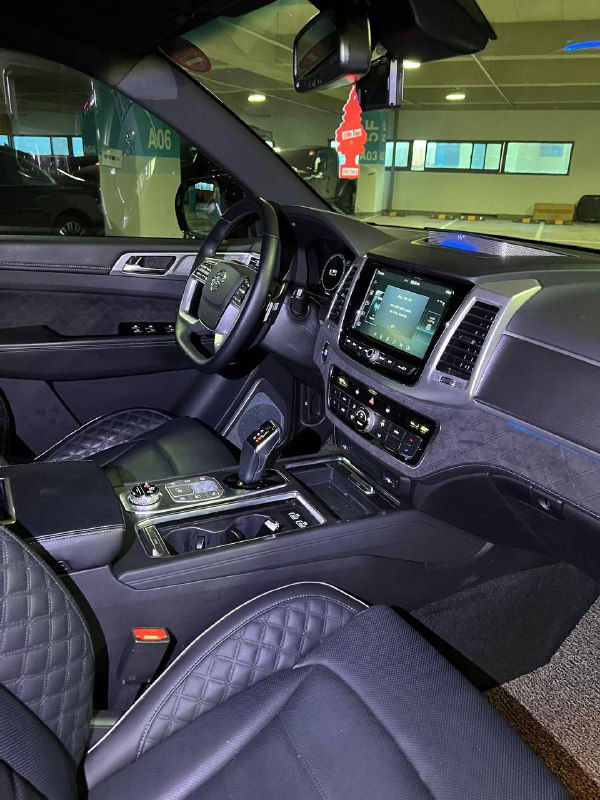 Интерьер SsangYong Rexton: центральная консоль, мультимедийный экран, селектор передач и приборная панель со стороны водителя.