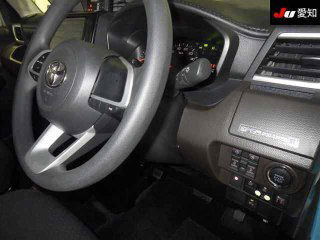 Крупный план интерьера Toyota Roomy 2022: рулевое колесо, часть приборной панели и элементы управления на водительской панели.