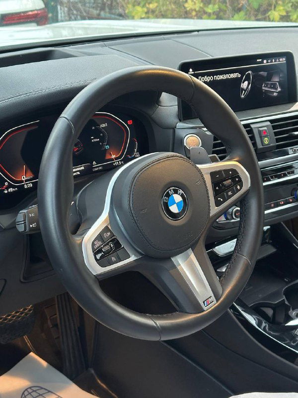 Интерьер BMW X3: спорт‑руль с логотипом BMW и элементы управления, демонстрация состояния салона и руля автомобиля.