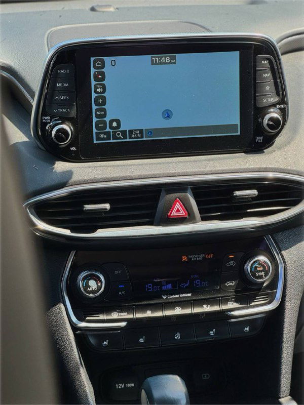 Центральная консоль Hyundai Santa Fe с мультимедийным экраном: отображение карты и элементы управления климатом на передней панели.
