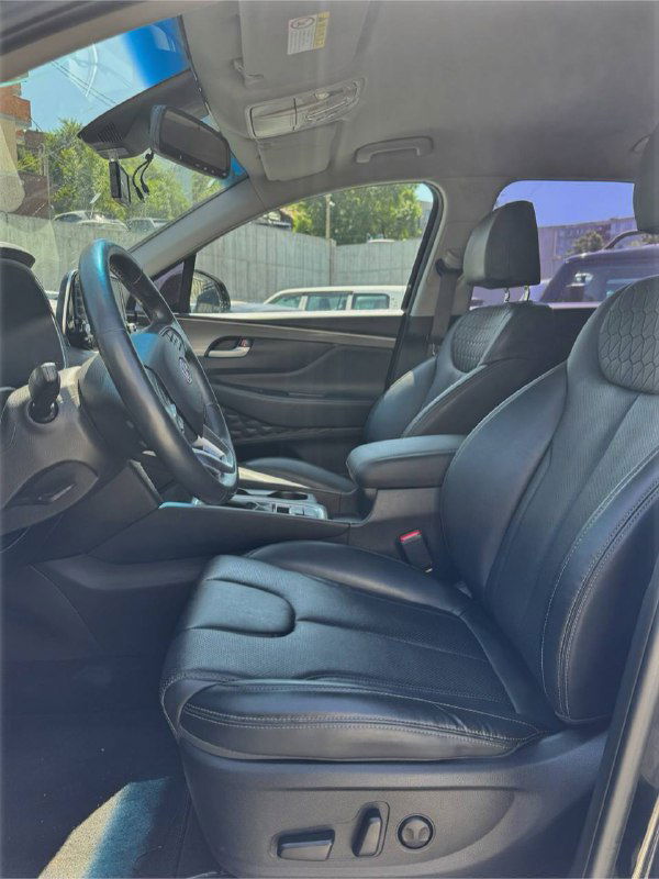 Передние сиденья и интерьер Hyundai Santa Fe: черная обивка, комфортные кресла и общее состояние салона видны на фото с открытой дверью.