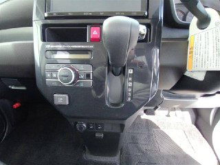 Крупный план центральной консоли Toyota Roomy 2022: селектор коробки передач, органы управления климатом и кнопки на панели управления.