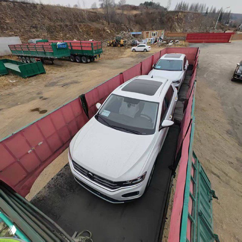 Вид сверху: два белых кроссовера Volkswagen и Audi в грузовом отделении/на платформе перед отправкой в РФ; частичный обзор колес и крыш автомобилей.