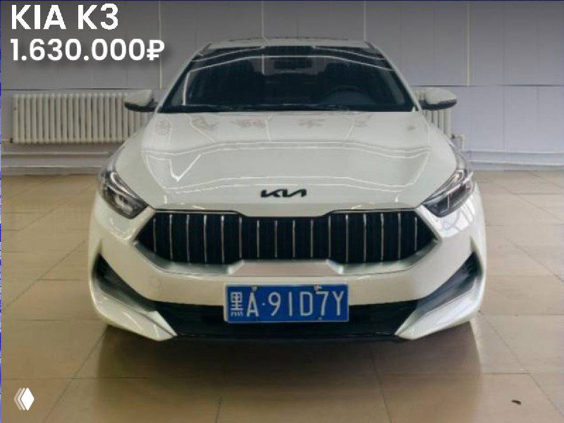 Фронтальный кадр белого KIA K3 (2021) в салоне в Китае, видна решётка радиатора, эмблема и китайский номерной знак.