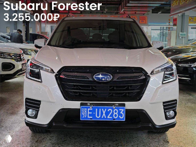 Фронтальный вид белого Subaru Forester (2022) в автоцентре, видна большая решётка, фары и китайский регистрационный знак.