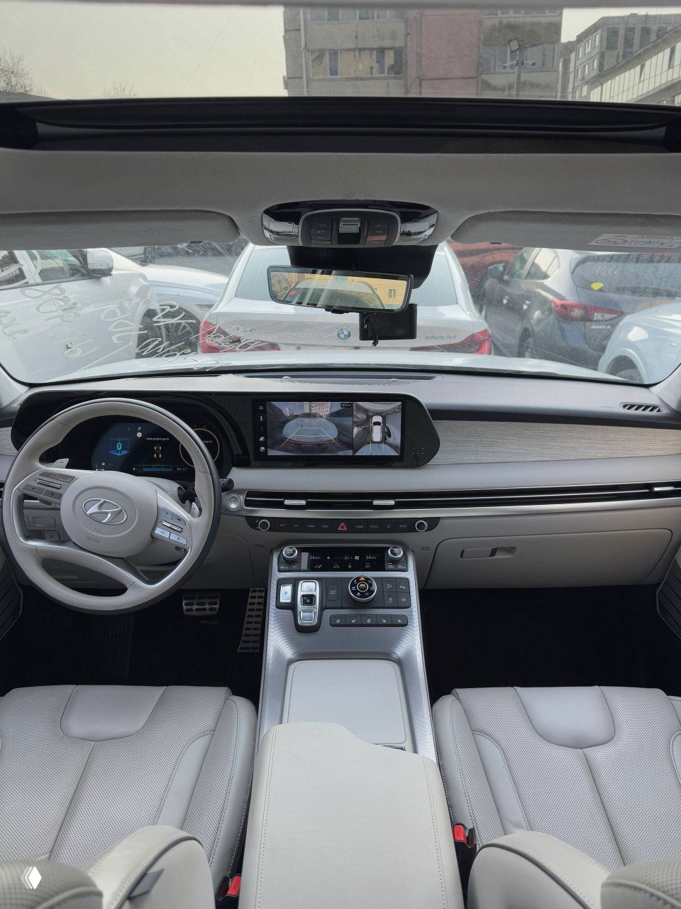 Салон Hyundai Palisade 2023: общий вид приборной панели, мультимедиа экран и передние сиденья — снимок для проверки состояния интерьера.