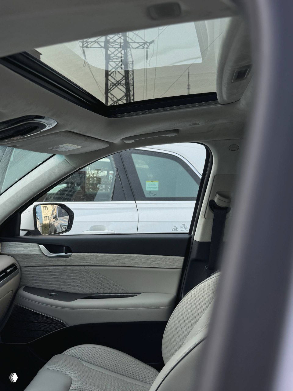 Салон Hyundai Palisade с панорамным люком в крыше: видно верхнюю отделку потолка, люк и боковую часть переднего пассажирского сиденья.