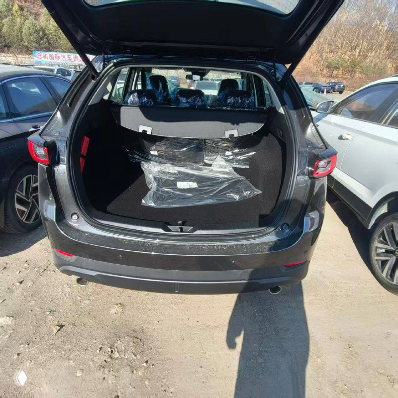 Открытый багажник Mazda CX-5 с защитными материалами внутри: вид из задней части на пространство для груза и упаковку.