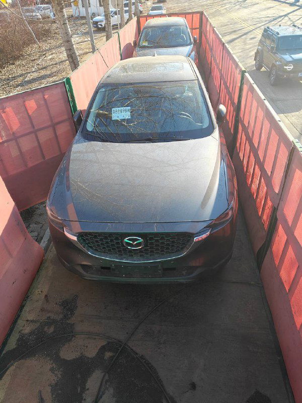 Mazda CX-5 в контейнере или на платформе при подготовке к отправке: вид сверху и спереди, автомобиль размещён внутри транспорта.