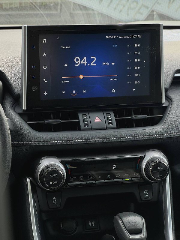 Центральная консоль Toyota RAV4: мультимедийный экран, отображающий радиочастоту, а также элементы управления климатом и мультимедиа.