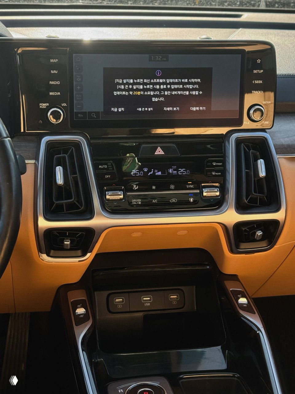 Центральная консоль KIA Sorento с широким сенсорным экраном мультимедиа и блоком климат-контроля; на экране видно сообщение на корейском языке.