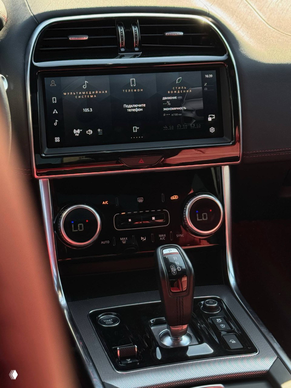 Центральная консоль Jaguar XE L: сенсорный экран мультимедиа, органы управления климатом и селектор автоматической коробки передач.