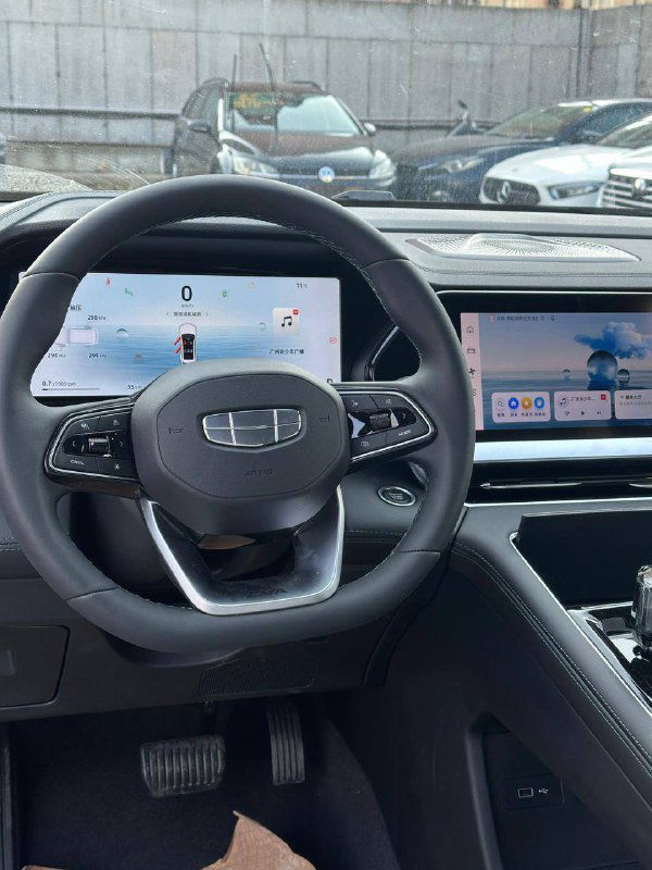 Фотография рулевого колеса и приборной панели Geely Monjaro 2025: цифровая приборка и большой центральный экран мультимедиа, детализация передней части салона.