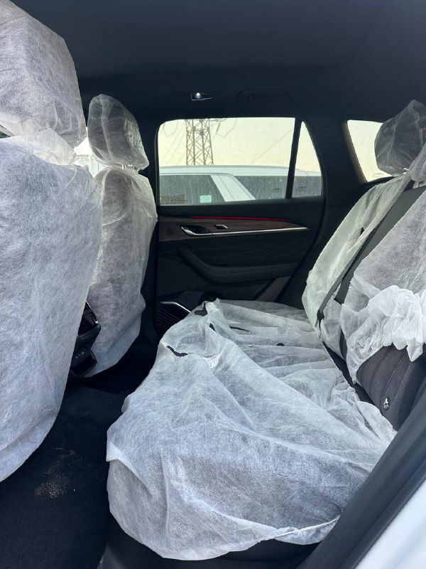 Вид на задние сиденья Geely Monjaro 2025 с защитными чехлами, показано пространство для ног, дверные панели и общая компоновка салона.