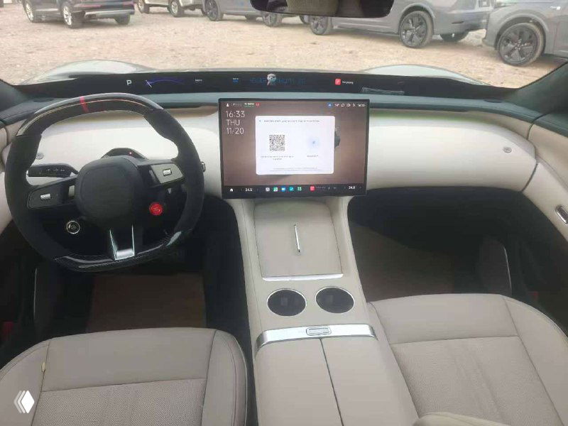 Салон Xiaomi YU7 max — крупный план центральной консоли с большим вертикальным сенсорным экраном, руль и элементы управления видны четко.