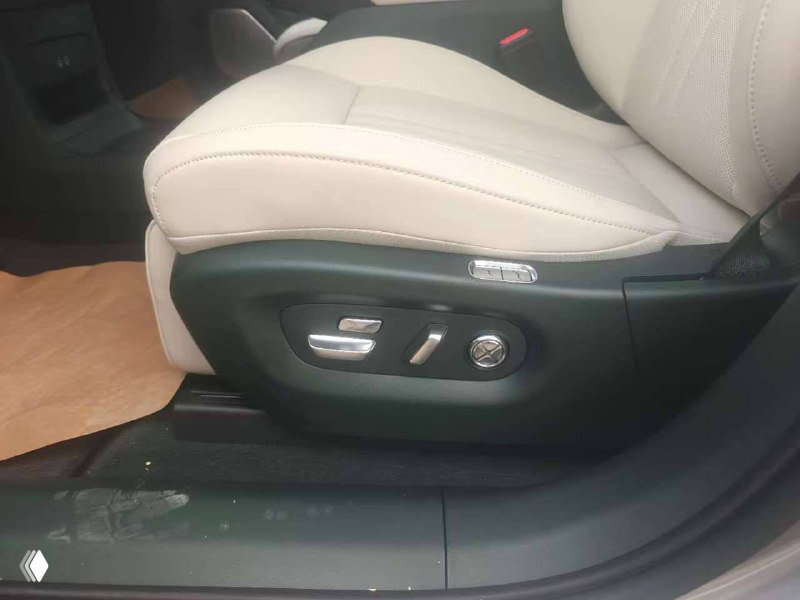 Переднее сиденье водителя в Xiaomi YU7 max с электроприводом — кнопки регулировки на боковой панели сиденья и бежевый кожаный салон.