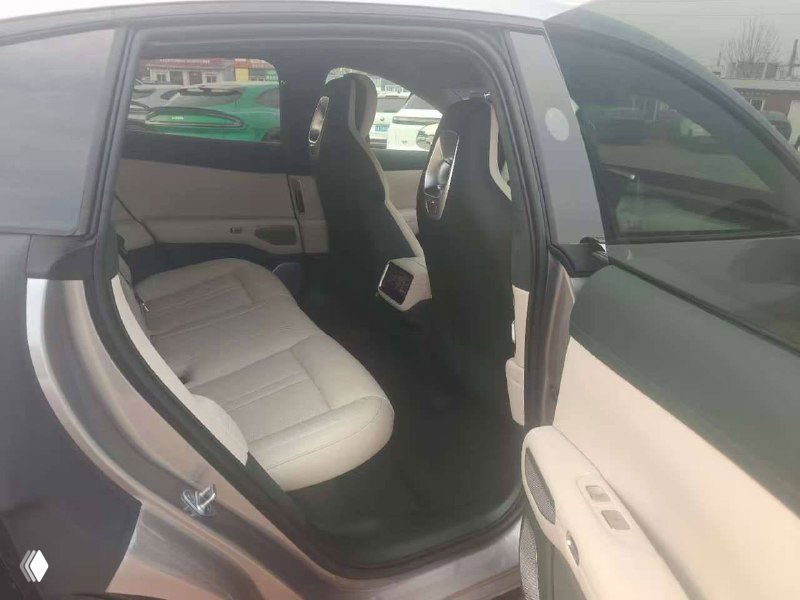 Задний ряд сидений Xiaomi YU7 max — пространство для пассажиров, бежевые сиденья и торцы передних кресел, общий вид салона сзади.