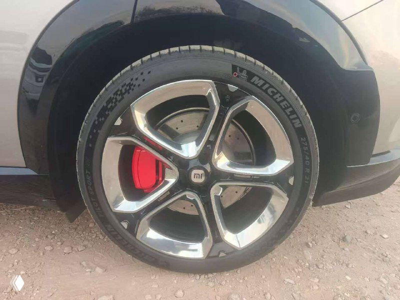 Колесо и тормозной суппорт Xiaomi YU7 max крупным планом: легкосплавный диск, красный тормозной суппорт и маркировка шин Michelin.
