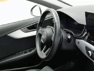 Рулевое колесо и приборная панель Audi A4L, чёрная кожа и декоративные вставки, фото подчёркивает сохранность салона и отделки.