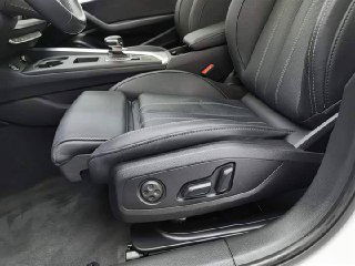 Переднее сиденье водителя Audi A4L в чёрной коже с электроприводом и видимыми регулировками, хорошее состояние обивки и подголовника.