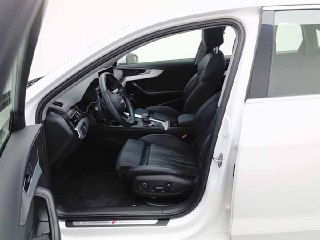 Открытая дверь и вид на водительское место Audi A4L со стороны пассажирской стойки — ракурс показывает порог, кресло и панель.