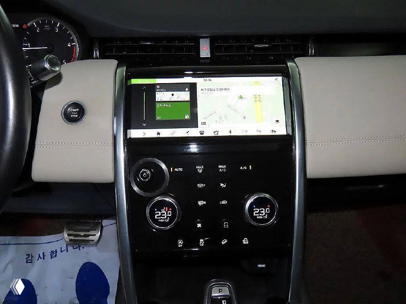 Центральная консоль Land Rover Discovery Sport с мультимедийным экраном и климат-контролем, показан интерфейс и элементы управления.